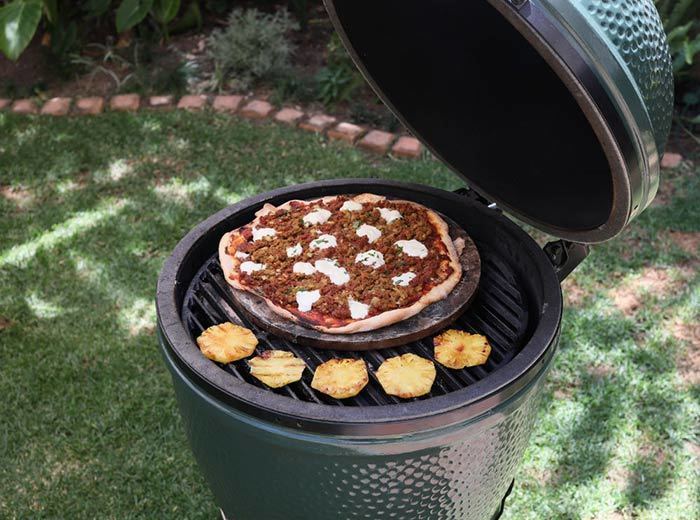 A Big Green Egg with a pizza stone